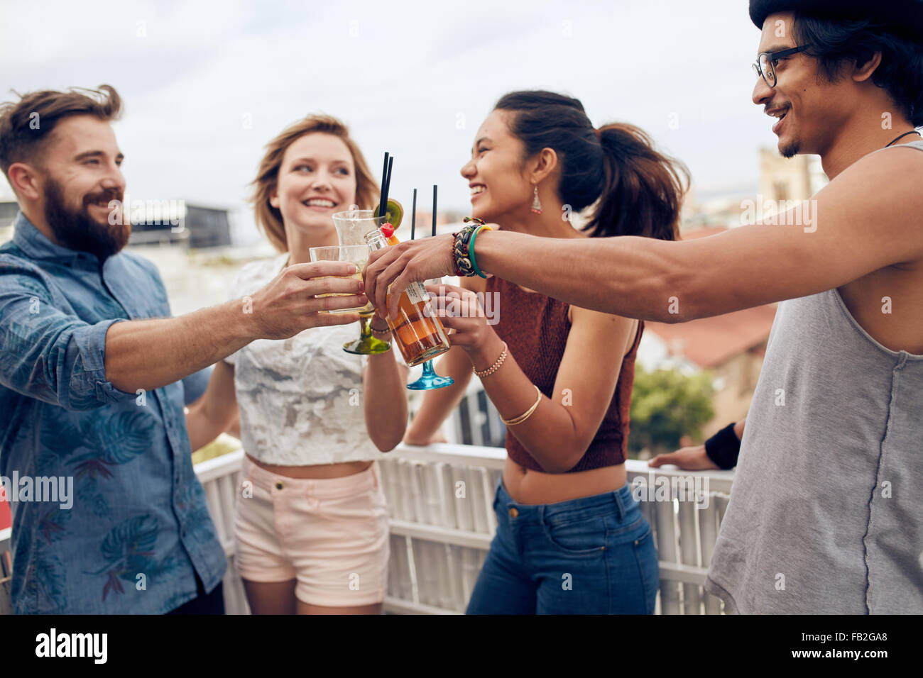 Friends enjoying cocktails at a party. Friends having fun and drinking cocktails outdoor on a