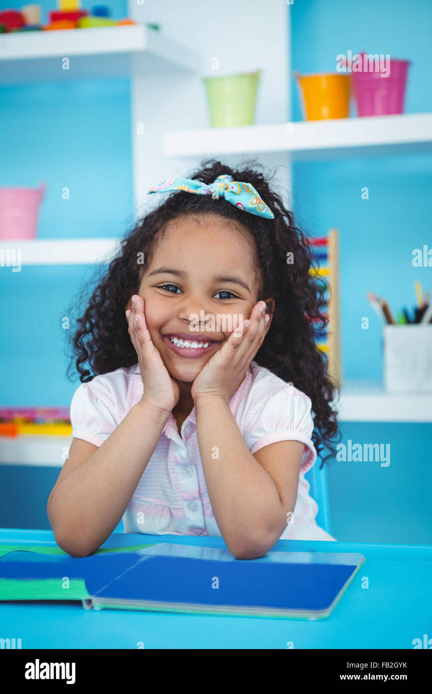 Cute girl with a book smiling at camera Stock Photo - Alamy
