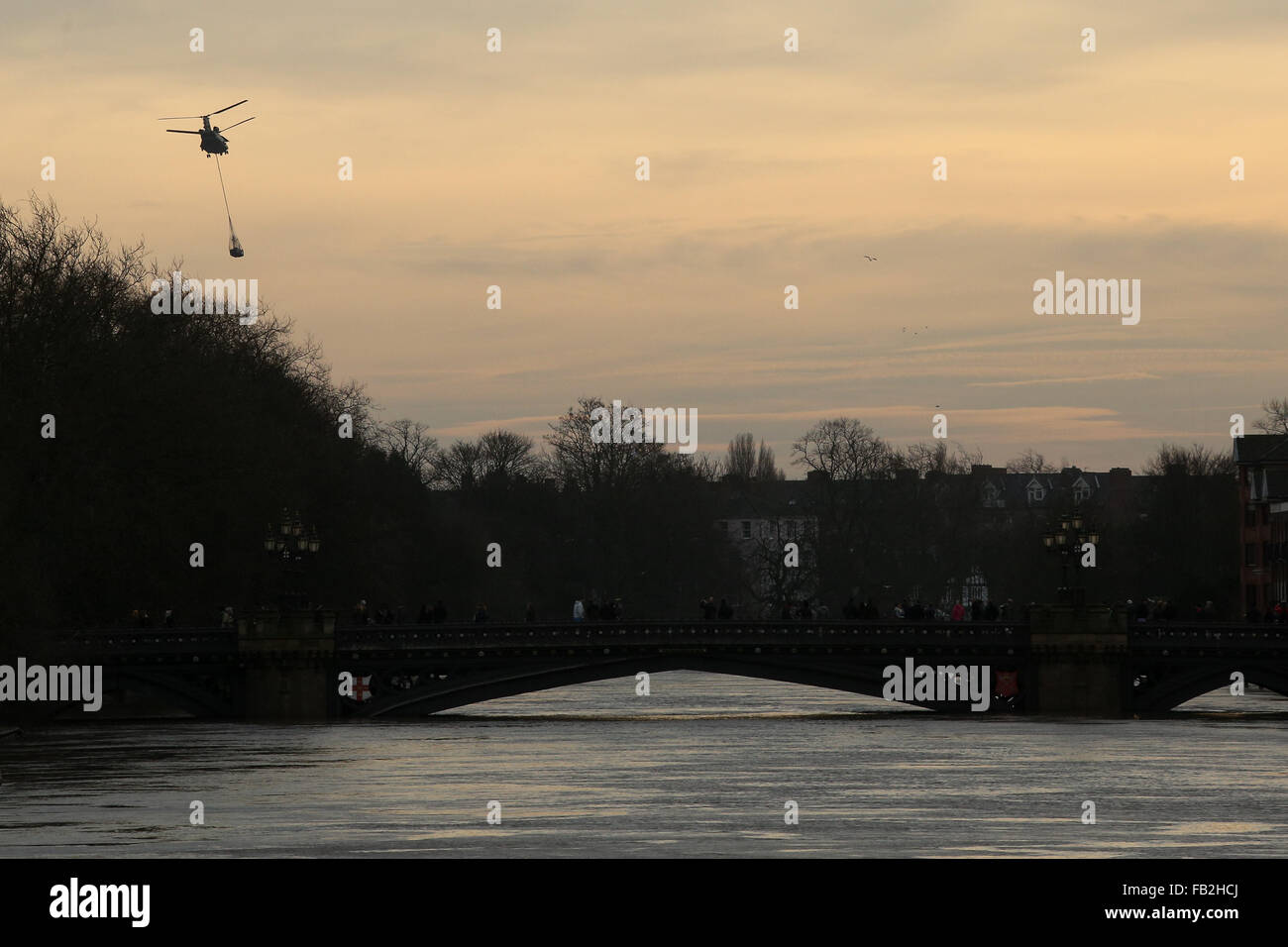 A military helicopter delivers supplies to the flood ravaged city of York, North Yorkshire, UK. Stock Photo
