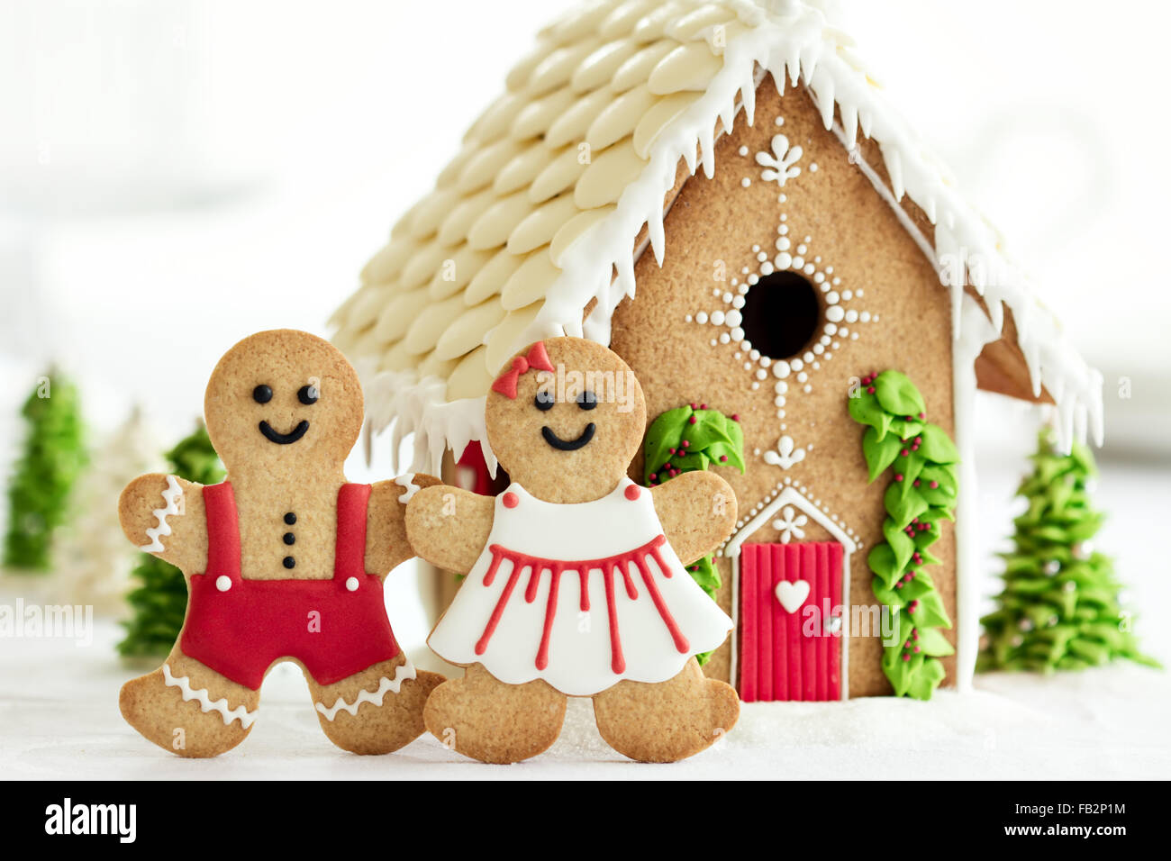 Gingerbread house with gingerbread couple in front Stock Photo