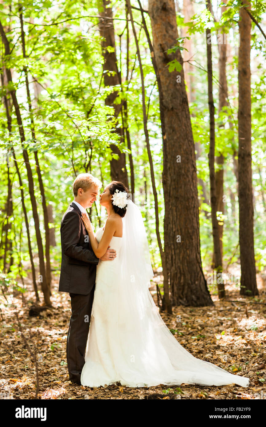wedding couple hugging, the bride holding a bouquet of flowers in her ...