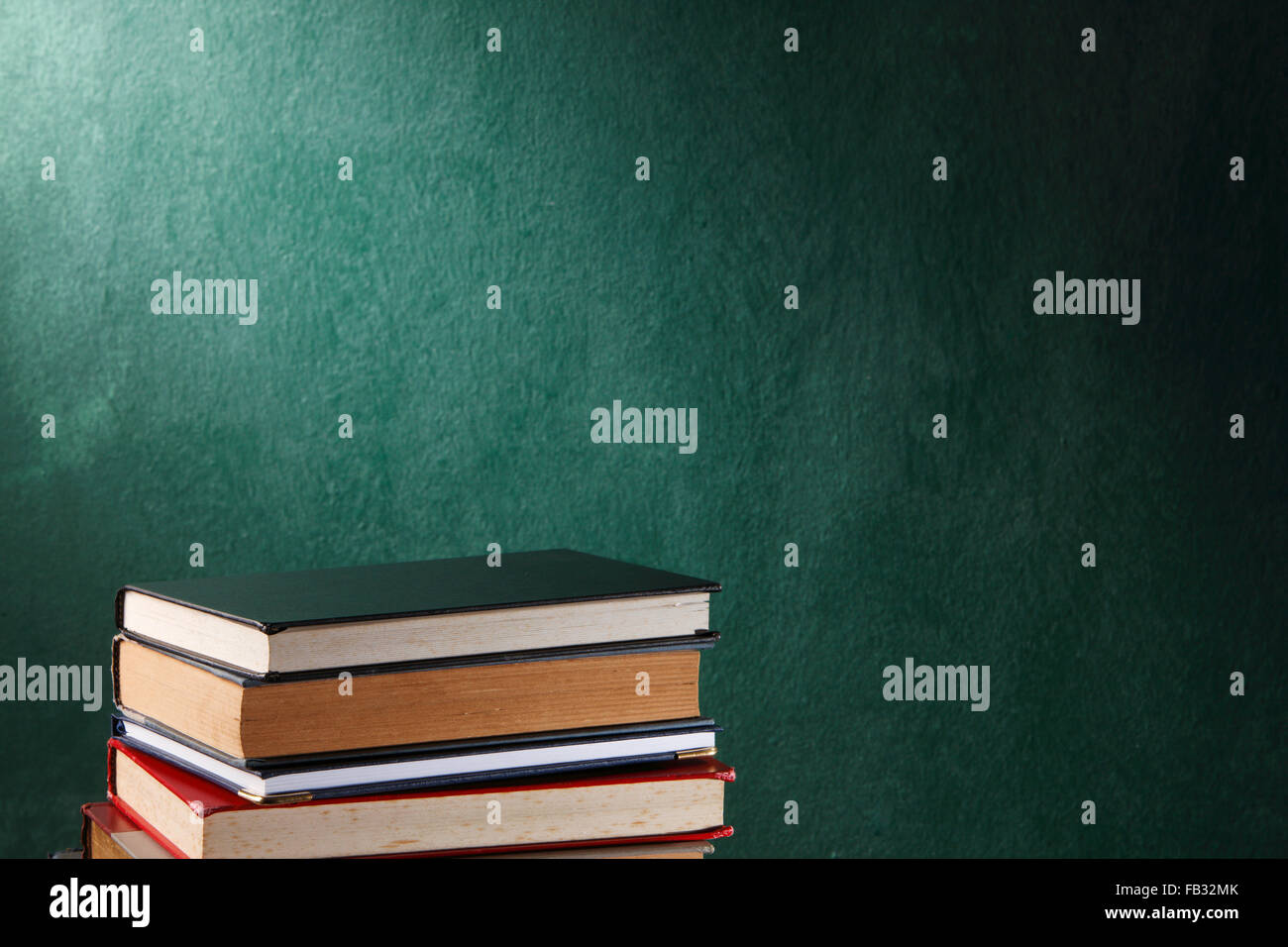 stack of books in front of the black board Stock Photo - Alamy