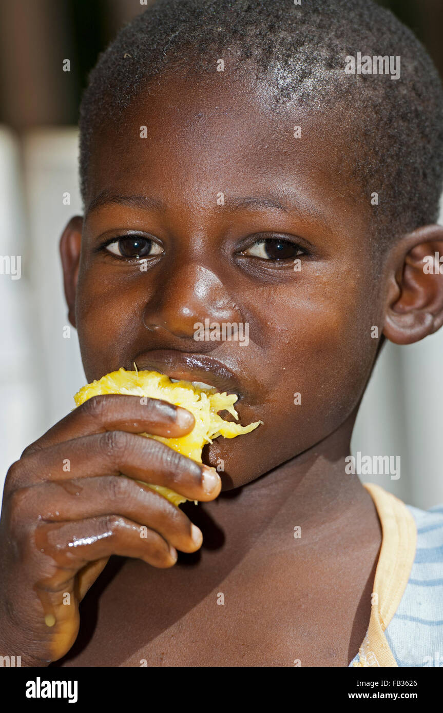 Young boy eating a juicy mango fruit. Kenya Stock Photo Alamy