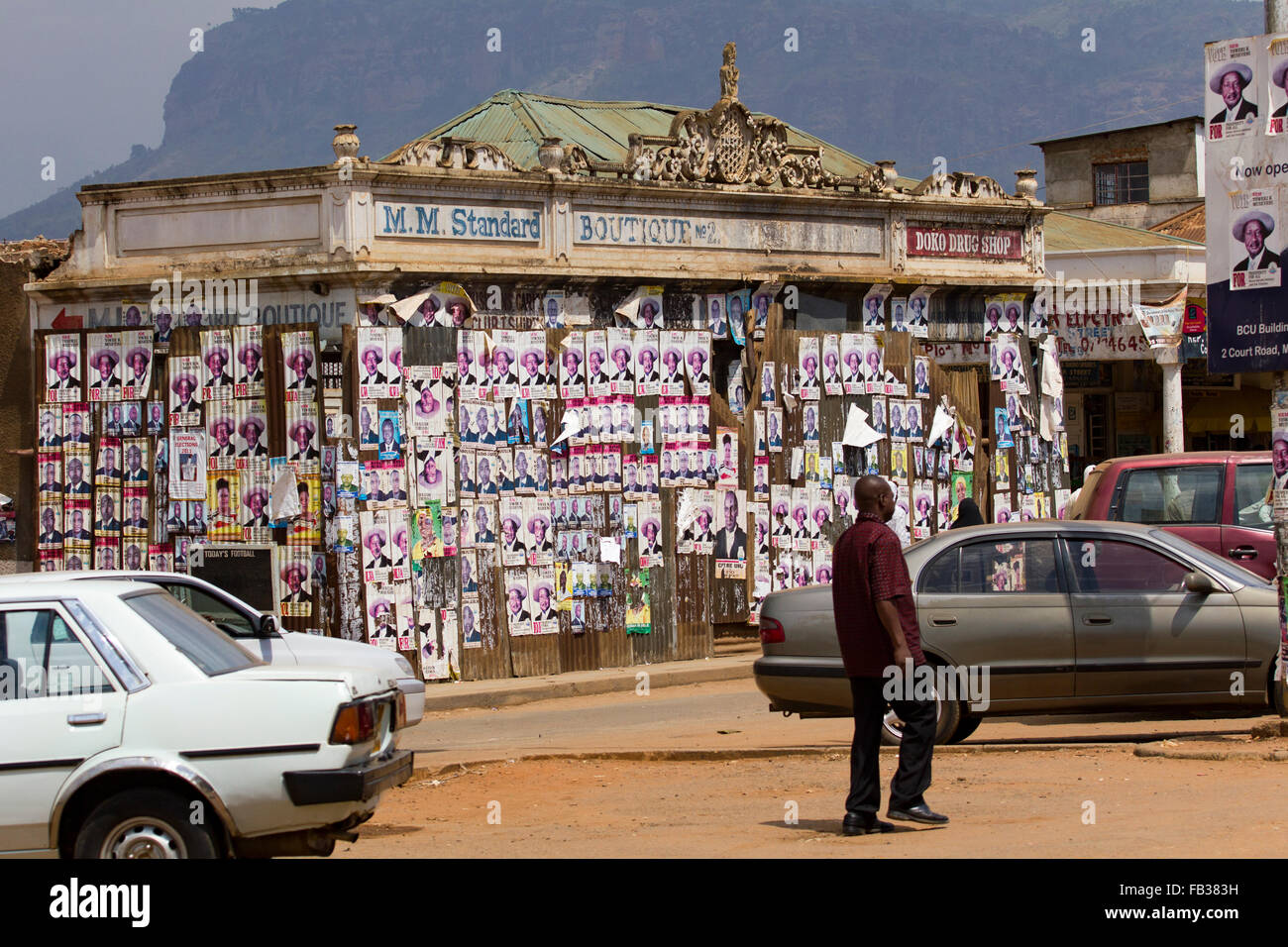Mbale, Uganda - February 11, 2011: Citizens passing by a wall filled with electoral propaganda promoting Ugandan president Mueve Stock Photo