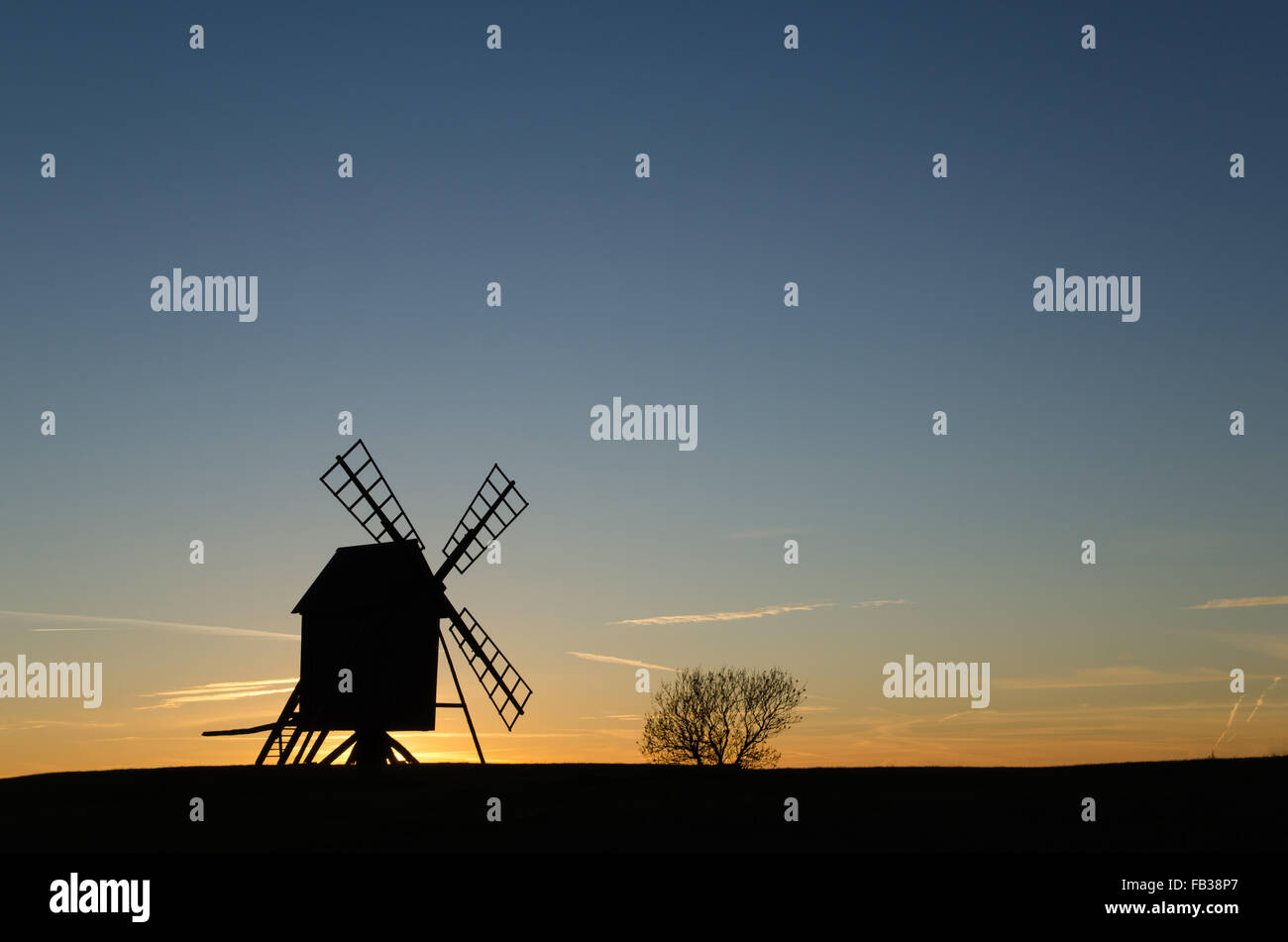 Old windmill silhouette in a clean composition by sunset at the Swedish island Oland, the island of sun and wind. Stock Photo
