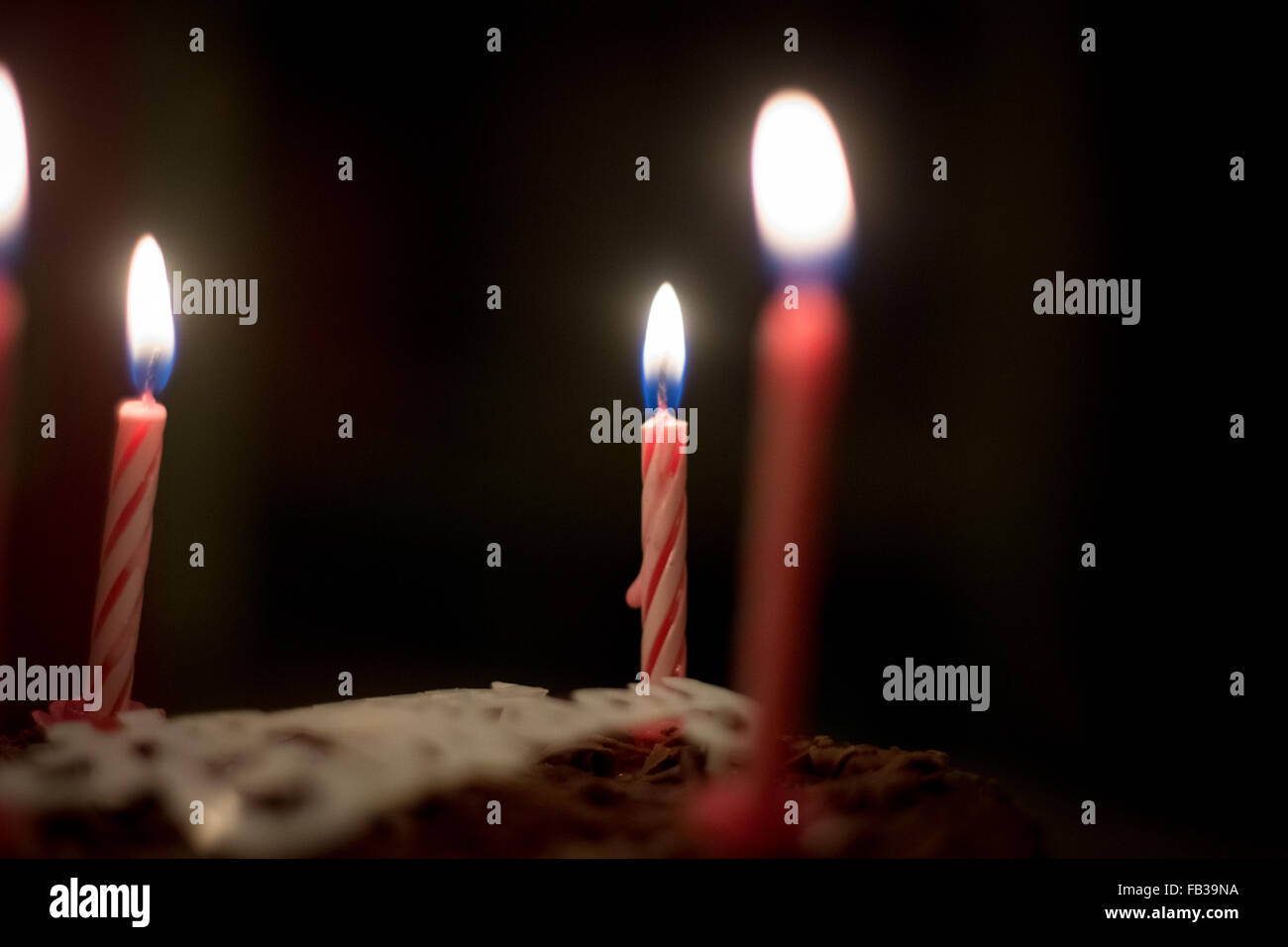 Lit pink birthday candles on top of a cake on a black background Stock ...