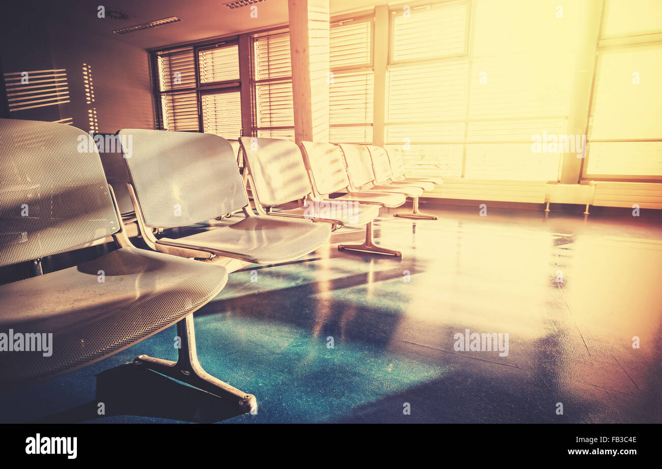 Vintage filtered picture of empty airport waiting room at sunrise. Stock Photo