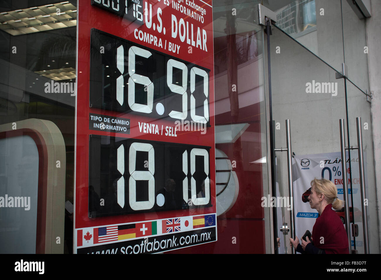 Mexico City, Mexico. 8th Jan, 2016. A woman walks past a board showing the exchange rate of the Mexican peso in relation to the U.S. dollar, in Mexico city, capital of Mexico, Jan 8, 2016. According to local press, the U.S. dollar was sold on Friday morning up to 18.20 pesos, seven cents more than the closing of Thursday. © Alejandro Ayala/Xinhua/Alamy Live News Stock Photo
