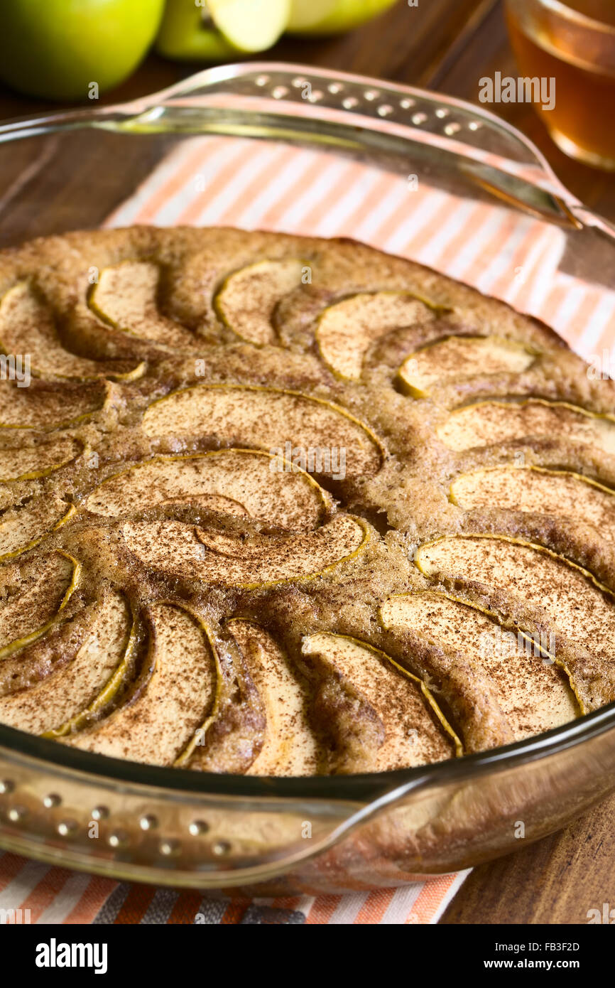 Homemade apple and cinnamon cake in glass dish, photographed with