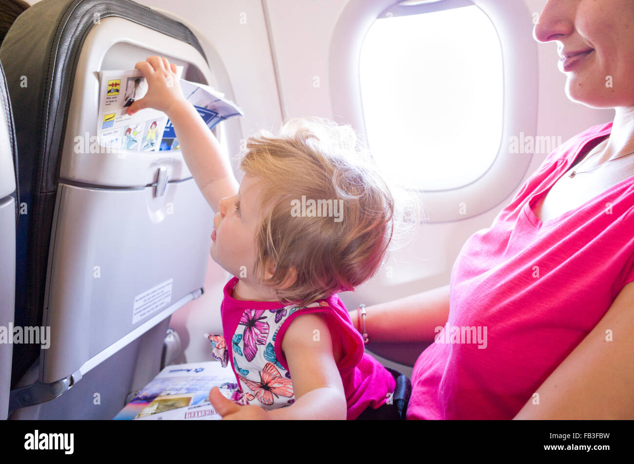 Mother travelling with one year old baby on an aeroplane Stock Photo