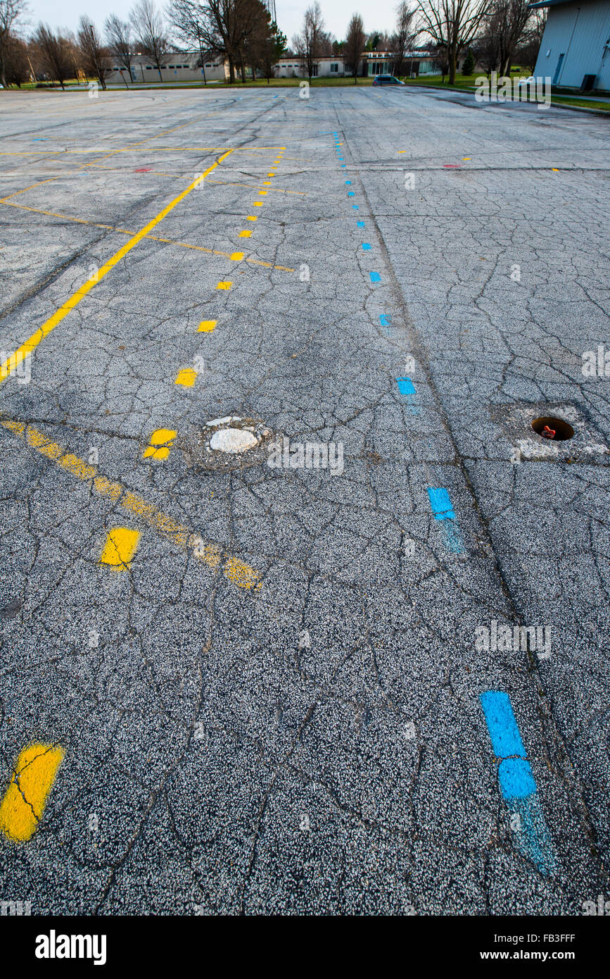 Painted blue and yellow lines on cracked asphalt in parking lot Stock ...