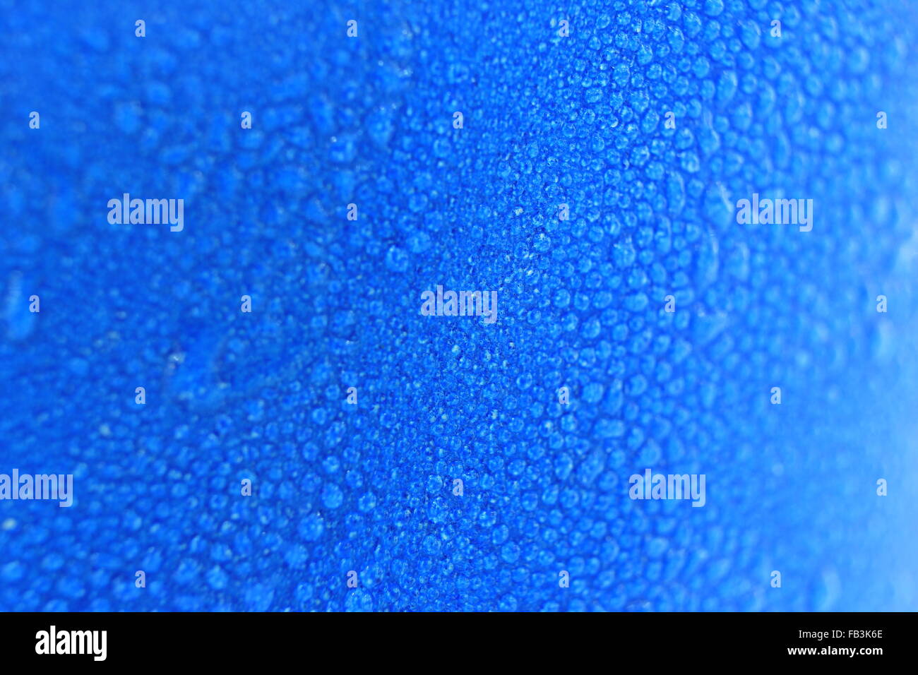 macro water drops background on blue cup. focus on center of the image ...