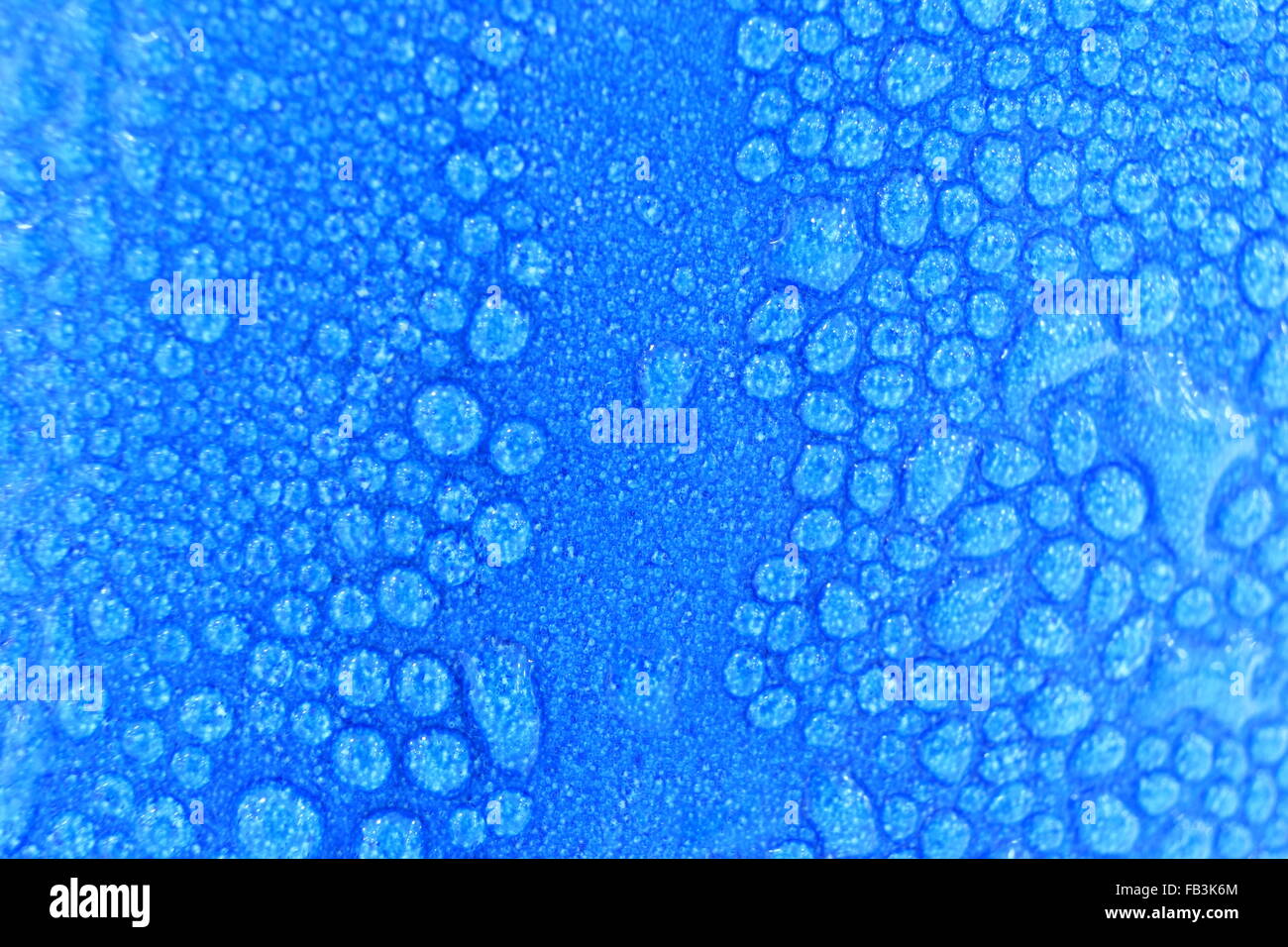 macro water drops background on blue cup. focus on center of the image ...