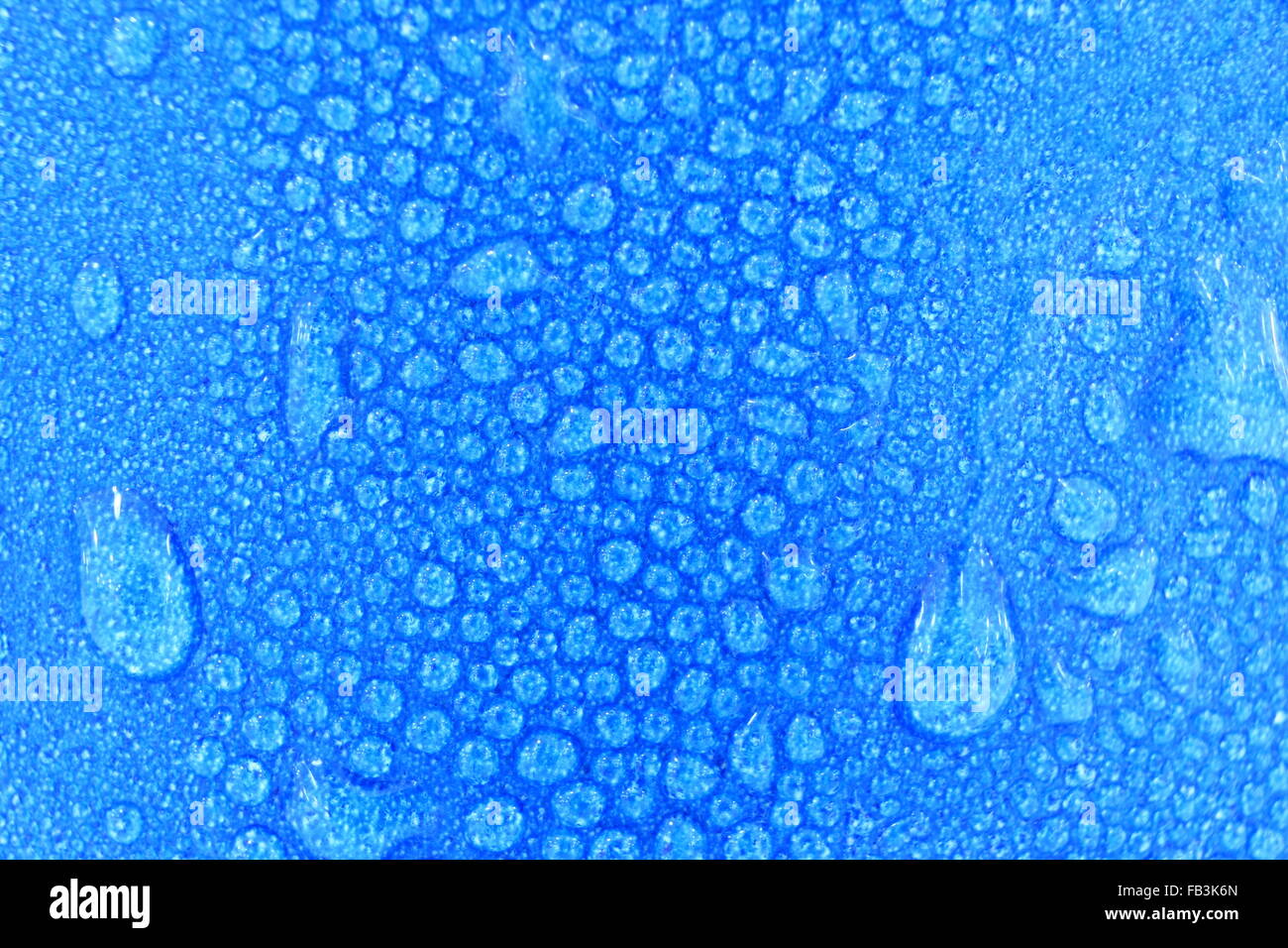 macro water drops background on blue cup. focus on center of the image ...