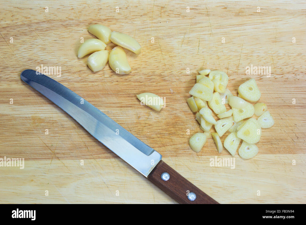 ิฟแาเพนีืก นด chopped garlic with a knife on the cutting board Stock Photo