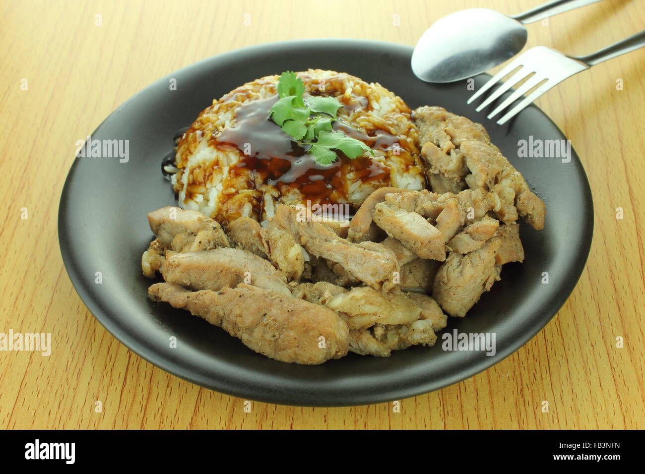 pork steak with rice and teriyaki sauce with spoon and fork Stock Photo