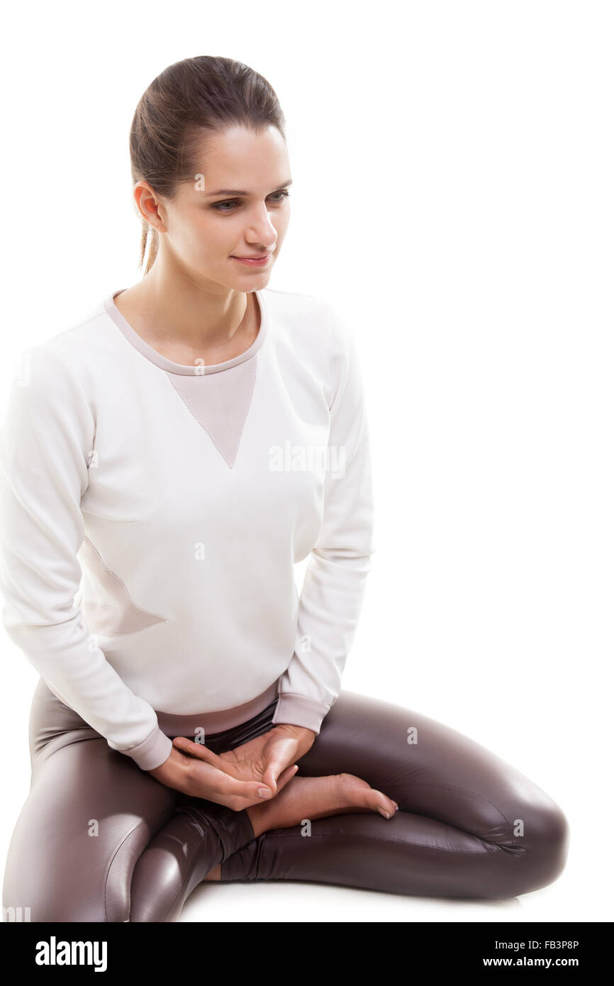 Yoga girl on white background sitting cross-legged in lotus pose Stock Photo