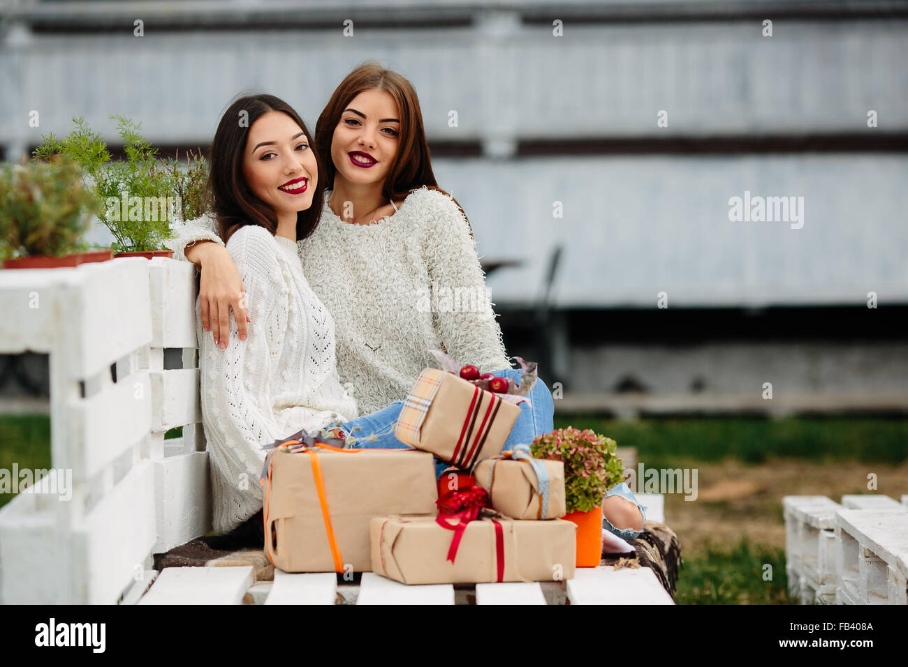 Two beautiful girls sitting on a bench Stock Photo - Alamy