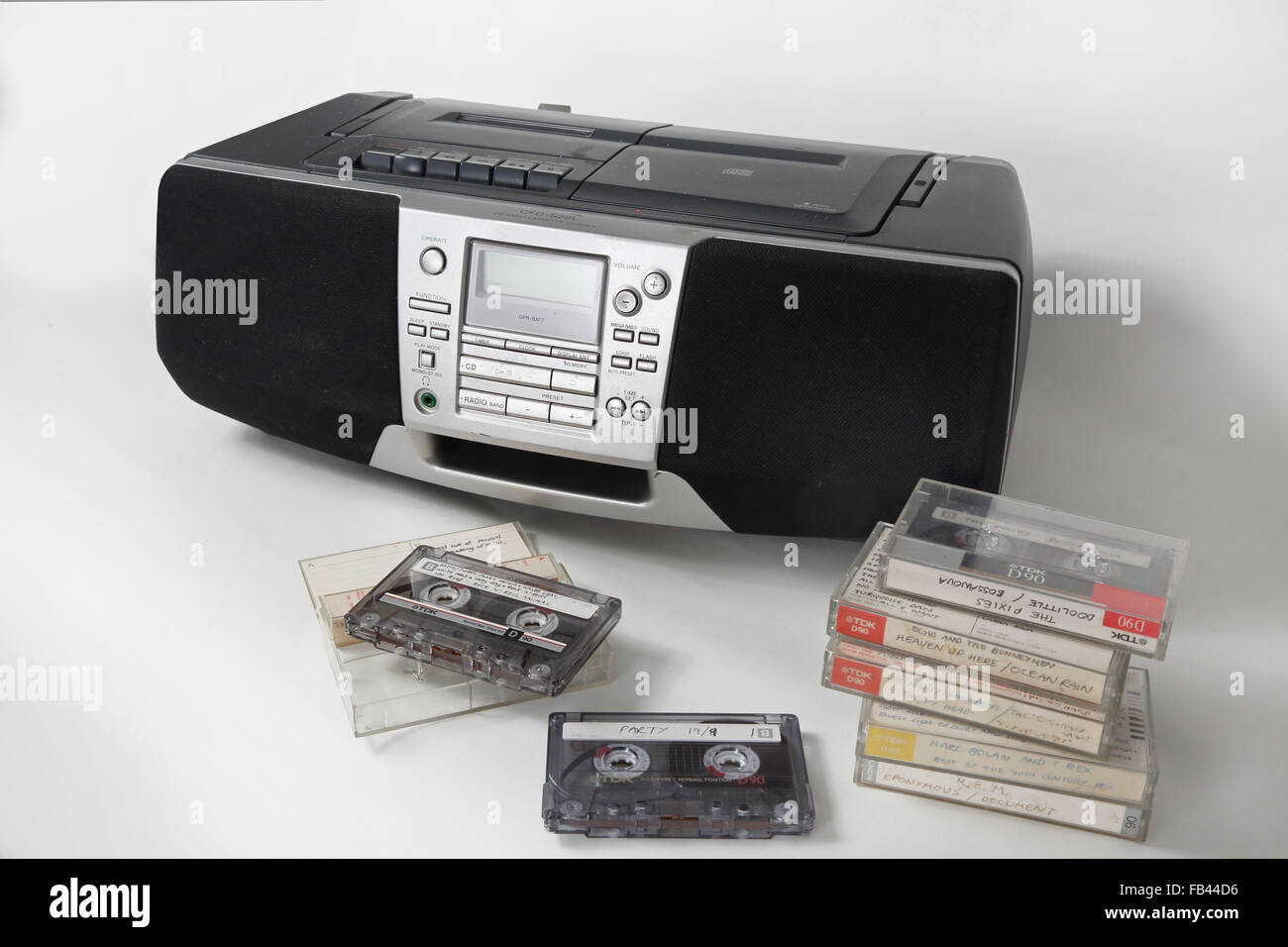 Home recorded cassette tapes stacked up in front of a 1990s style cassette, radio and and CD player Stock Photo