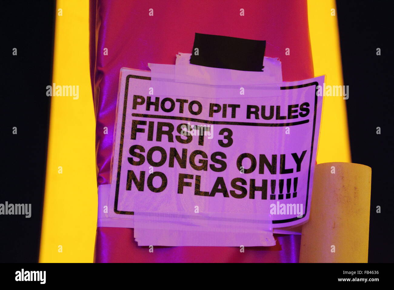 A sign warns accredited festival photographers to exit the stage pit after flash-free coverage of an artist's first three songs at a UK music festival Stock Photo