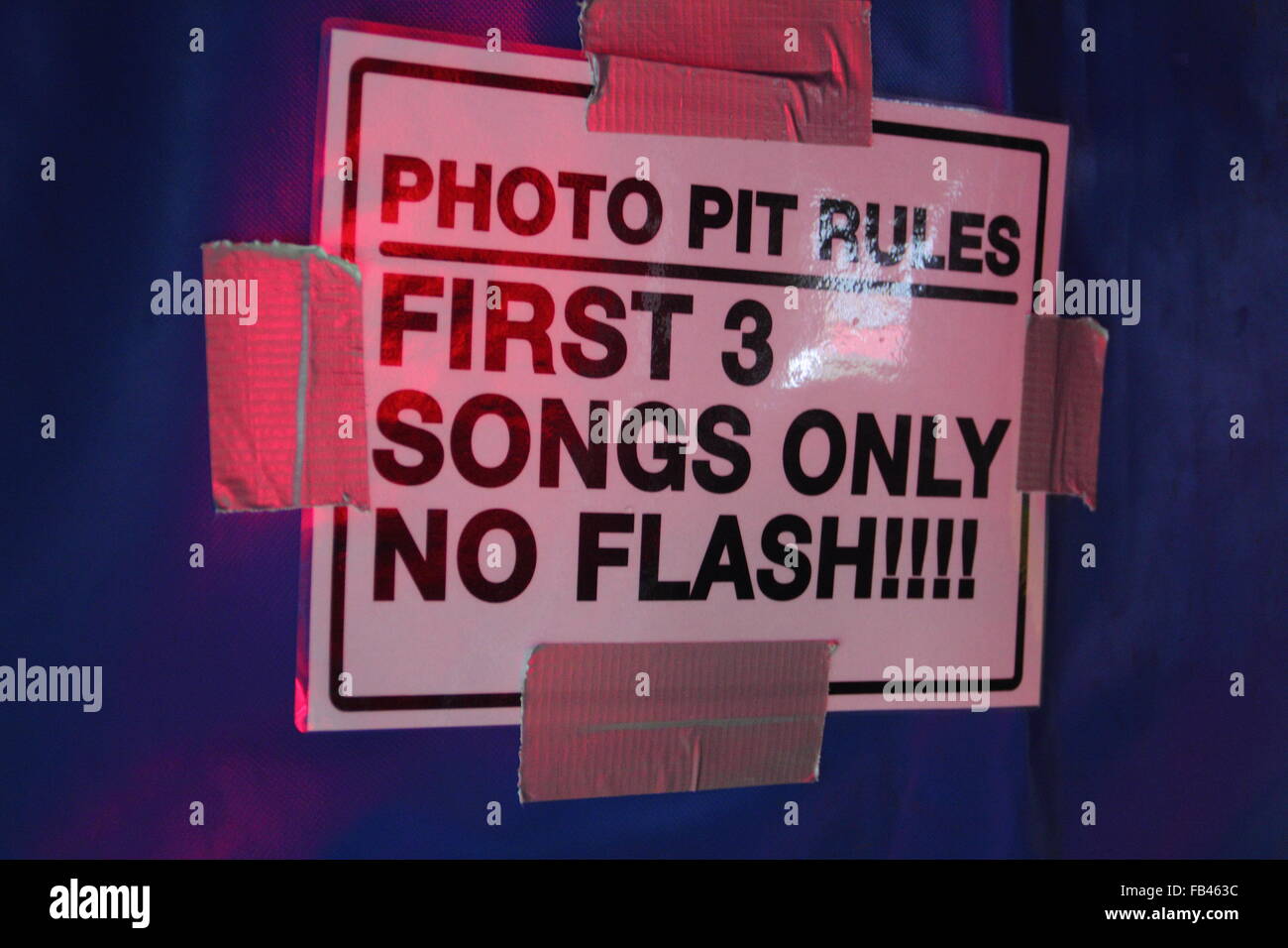 A sign warns accredited music photographers to exit the stage pit after flash free coverage of an artist's first three songs at a UK festival Stock Photo