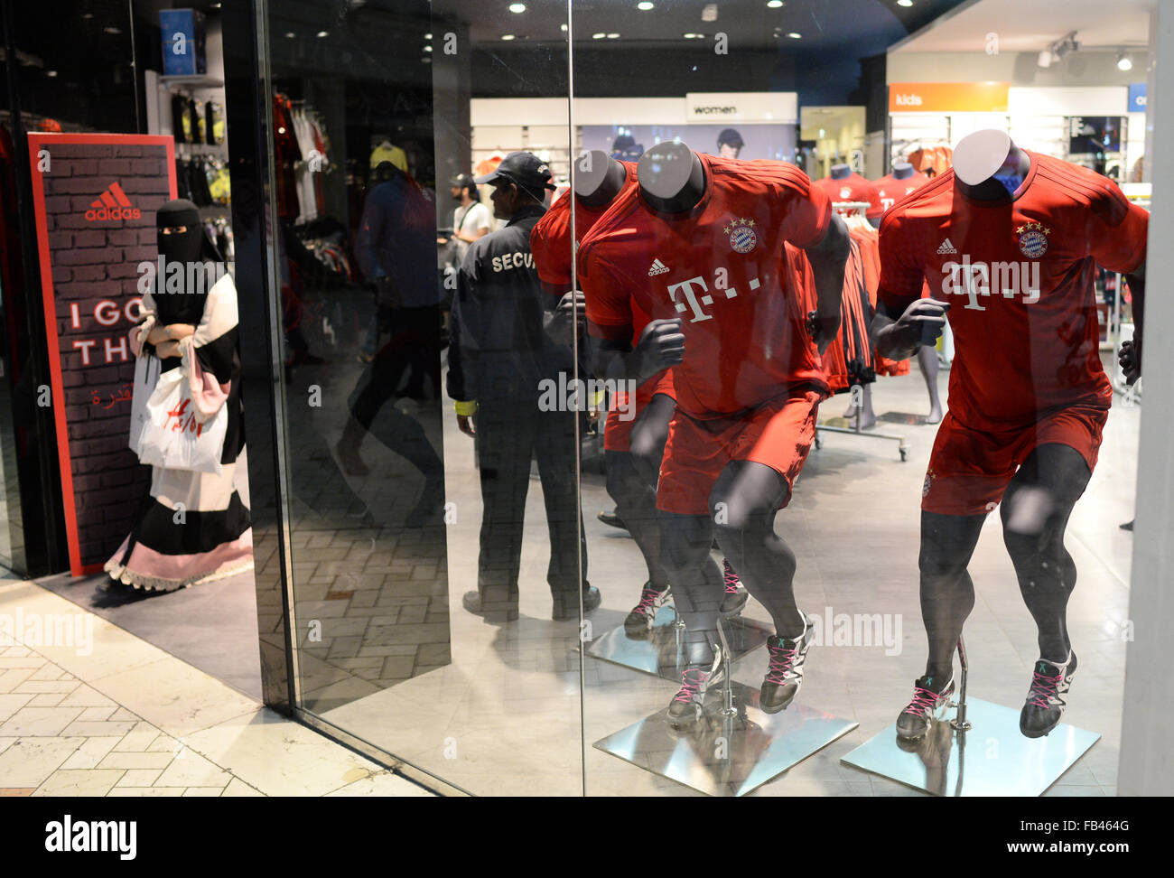 A woman wearing a Niqab the Adidas store at the Villaggio shopping mall Doha, 08 January 2016. Jerseys of German football club FC Bayern Munich are displayed in the window.