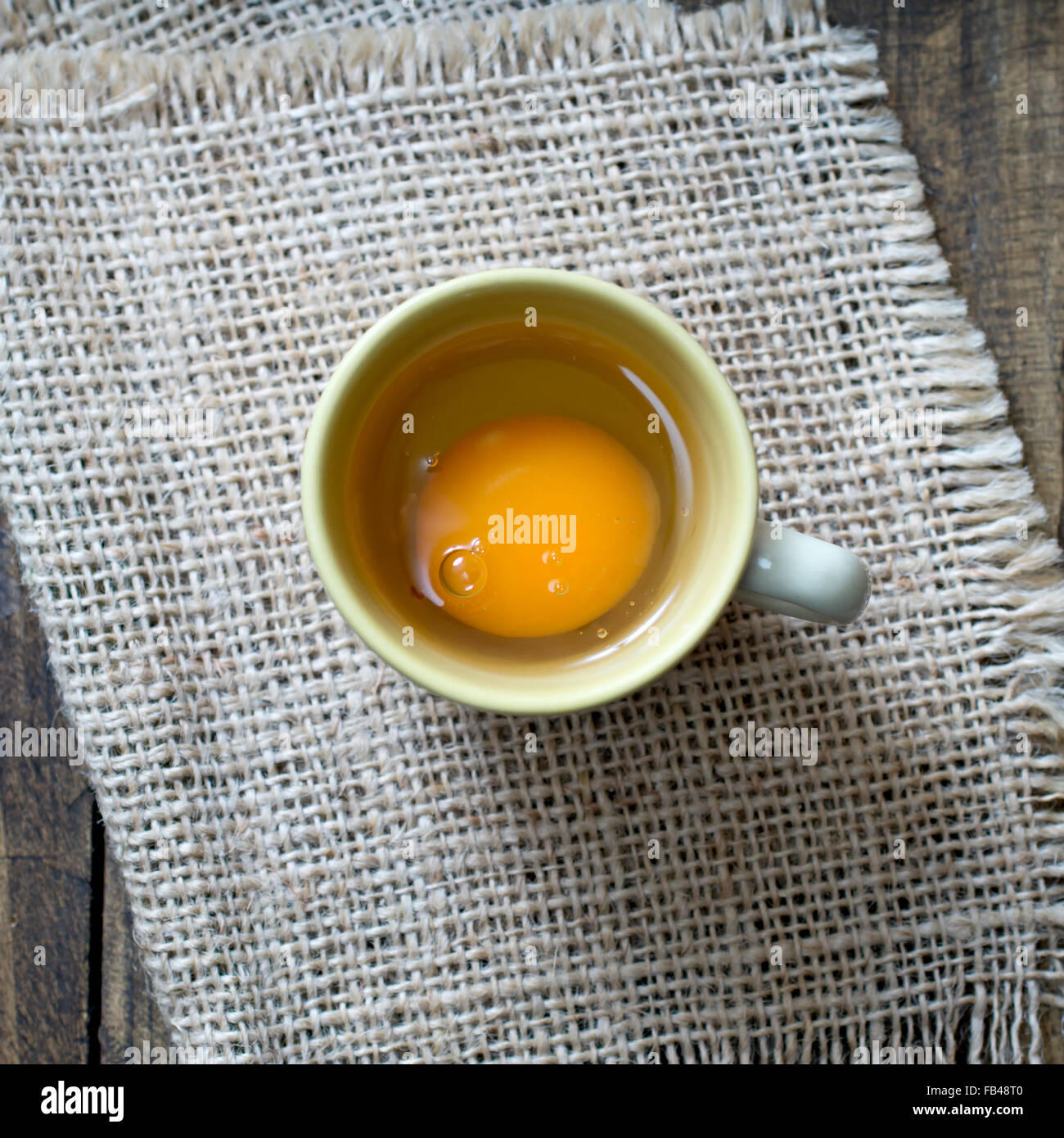 From above view of broken egg in a coffee cup Stock Photo