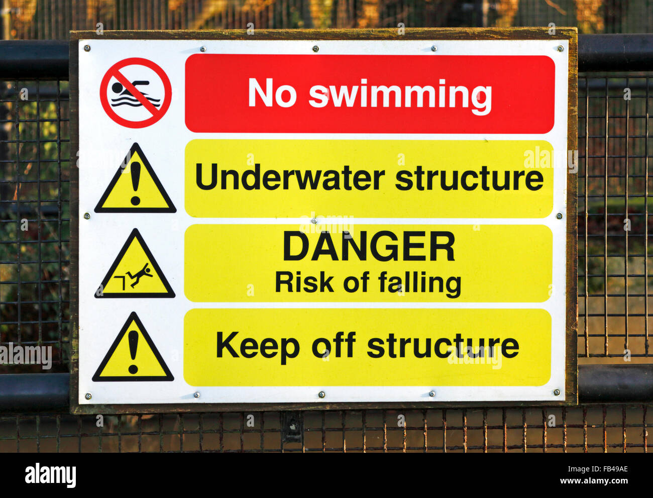 Safety sign by the old mill dam and weir on the River Bure at Horstead, Norfolk, England, United Kingdom. Stock Photo