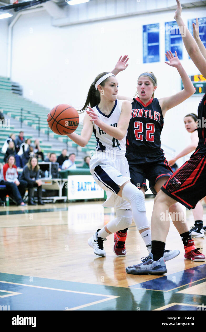 Player looking to pass the basketball while being stymied along the baseline during a high school basketball game. USA. Stock Photo