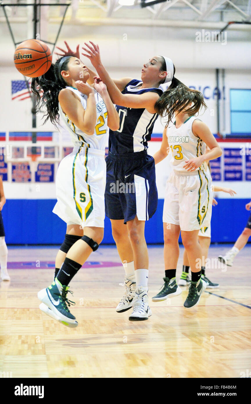 A high school forward, right, recoils from contact under the basket with a defender and losses control of the basketball. USA. Stock Photo