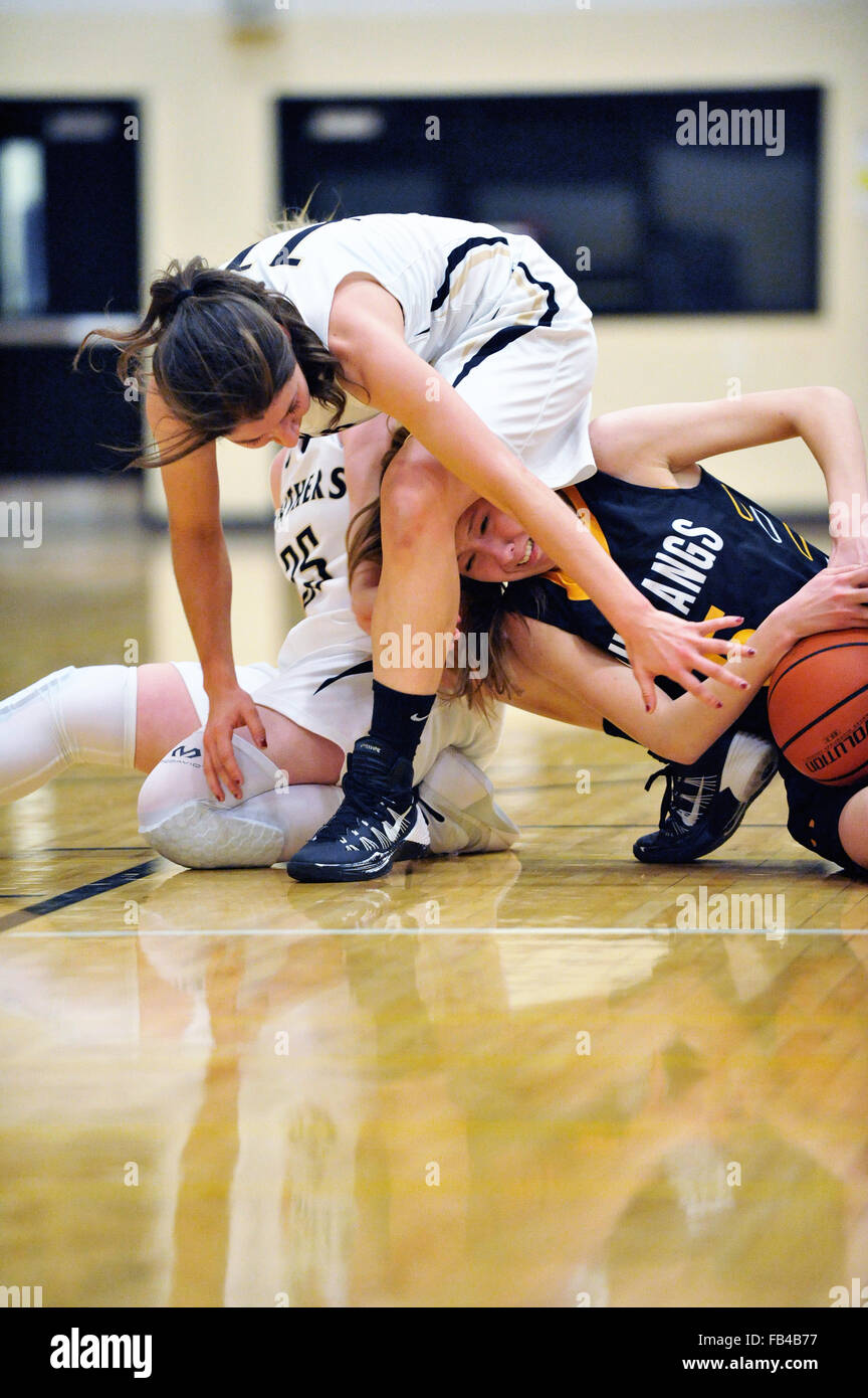 Players struggle to obtain possession of the basketball during a high school basketball game. USA. Stock Photo