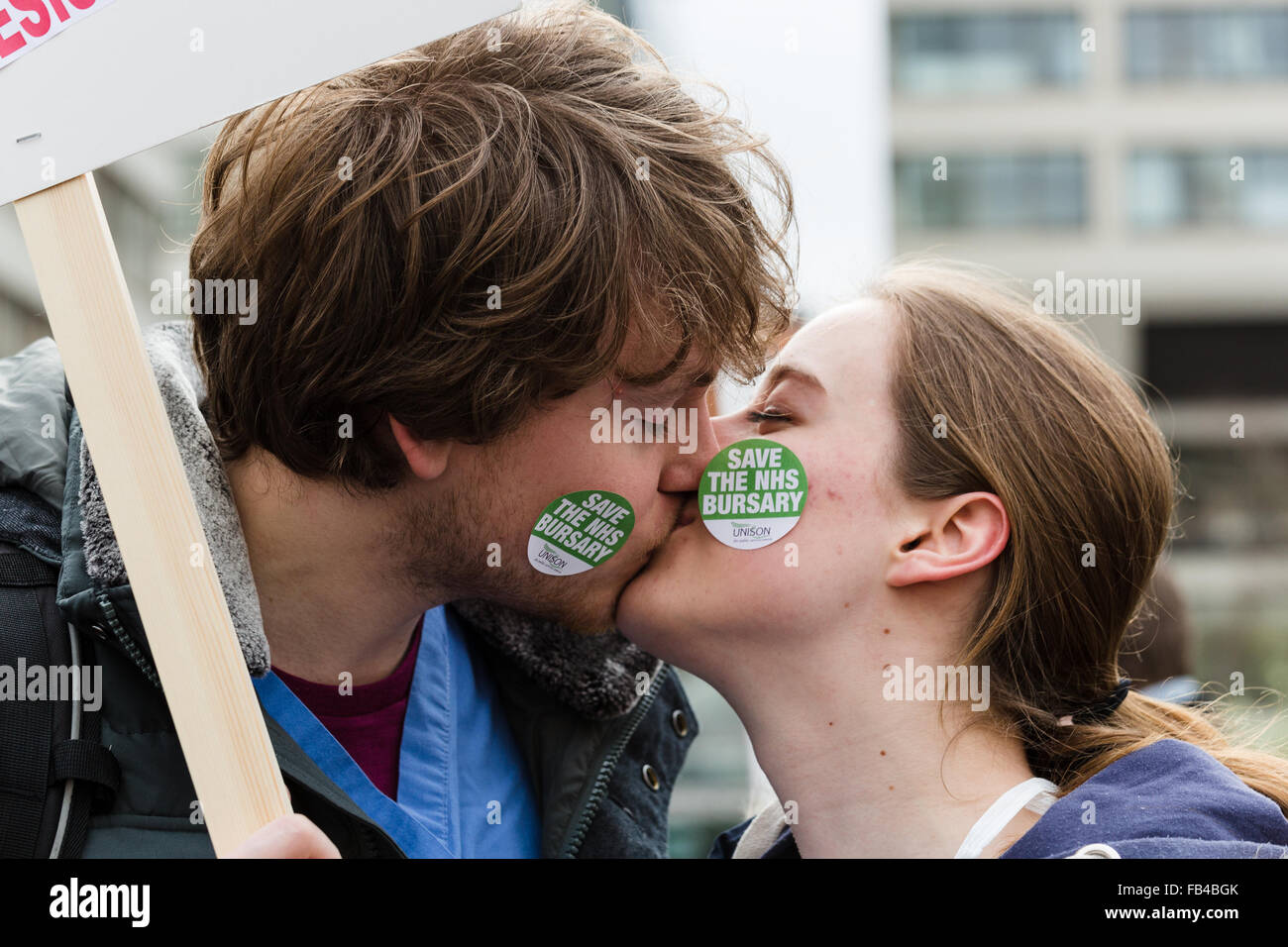 London, UK. 9th January 2016.Two nurses kiss as NHS student nurses, midwives and supporters take part in a protest march from St Thomas’ Hospital to Downing street to oppose the scrapping of nursing bursaries. In the 2015 Autumn Statement, Chancellor George Osborne, announced that NHS bursaries, which are paid to student nurses to cover living costs while they are studying and carrying out hospital work experience, will be abolished and instead converted into student loans that will have to be repaid. Credit:  London pix/Alamy Live News Stock Photo