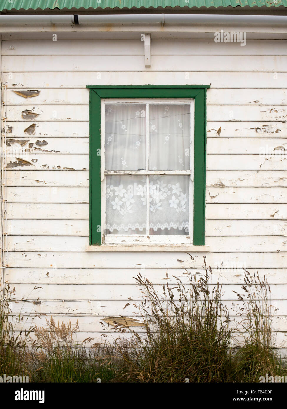 Falklands, Port Stanley, Allardyce Street, peeling painted window of wetherboarded cottage Stock Photo