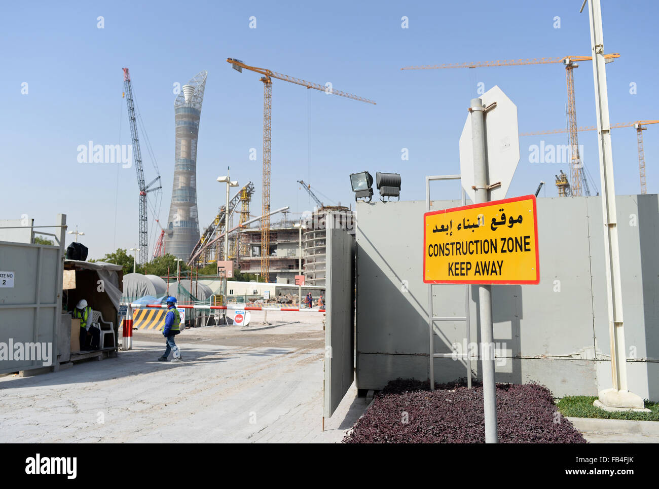 A sign reading "Construction Zone - Keep Away" stands at an entrance to the construction site of the Khalifa International Stadium in Doha, 09 January 2016. The stadium is currently undergoing renovation works. The Khalifa International Stadium is the first proposed host venue for the 2022 FIFA World Cup Qatar. In background is the hotel "The Torch". Photo: Andreas Gebert/dpa Stock Photo