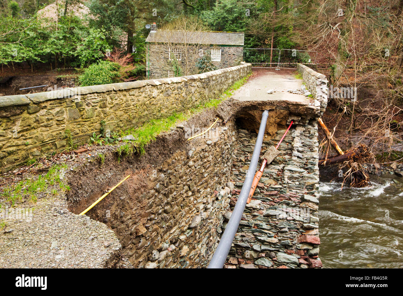 On Saturday 5th December 2015, Storm desmond crashed into the UK, producing the UK's highest ever 24 hour rainfall total at 341.4mm. It flooded many towns including Keswick. This shots shows Forge Lane bridge, an ancient stone bridge, severely damaged by the River Greta in flood. Stock Photo