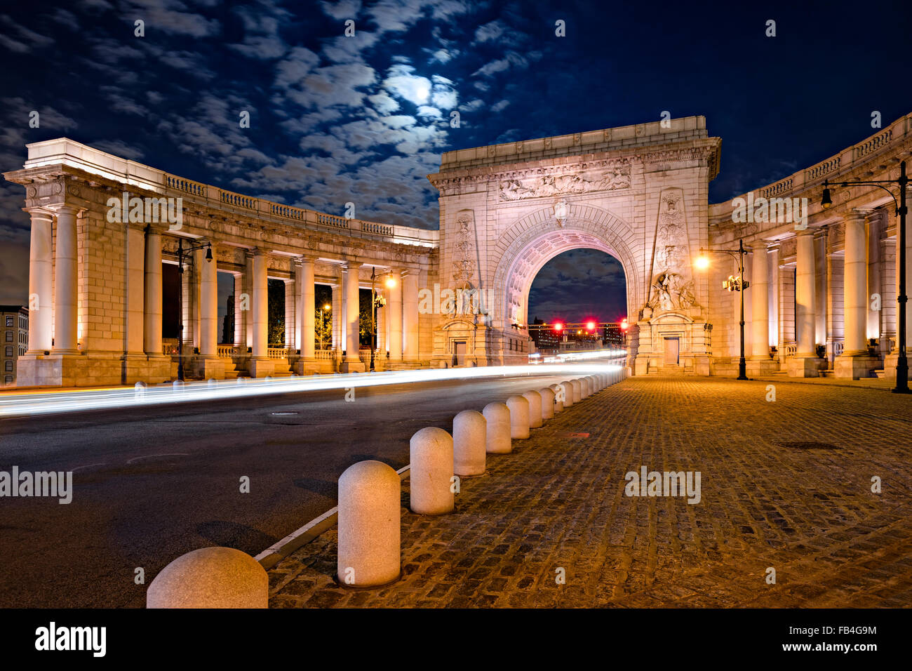 Illuminated Triumphal Arch and Colonnade of Manhattan Bridge Entrance in moonlight, Chinatown, Lower Manhattan, New York City. Stock Photo