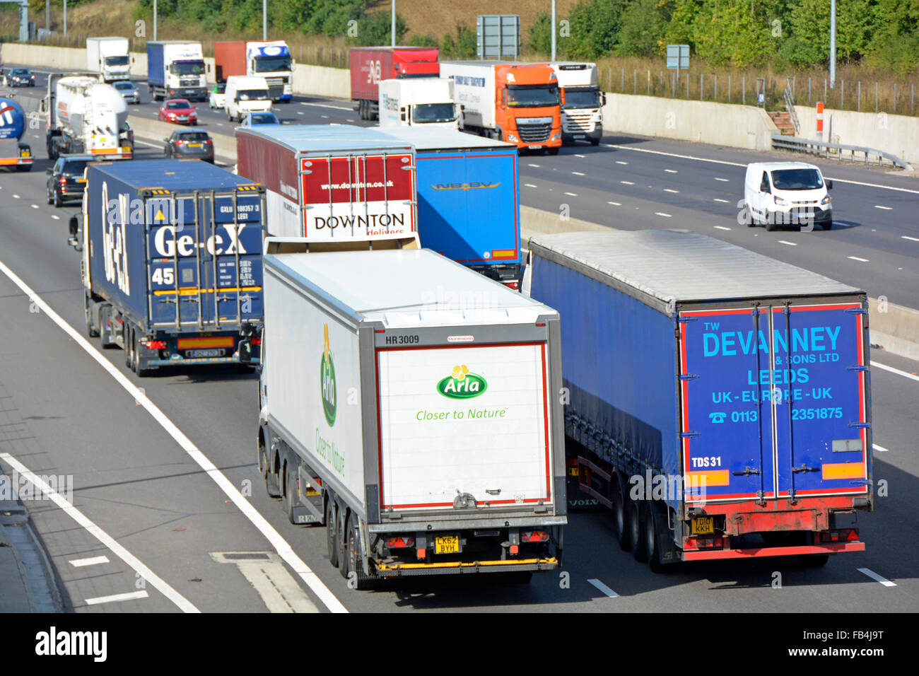 Cluster of five hgv lorries involved in overtaking on three lanes of four lane section of the M25 motorway Stock Photo