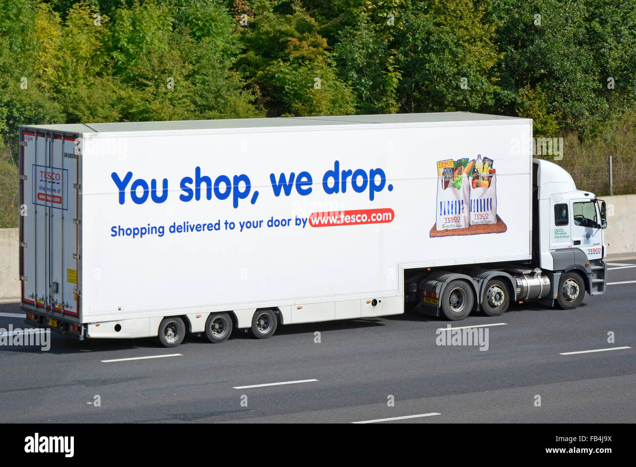 Side view hgv supermarket food store supply chain grocery lorry truck with trailer advertising Tesco home food delivery business driving UK motorway Stock Photo