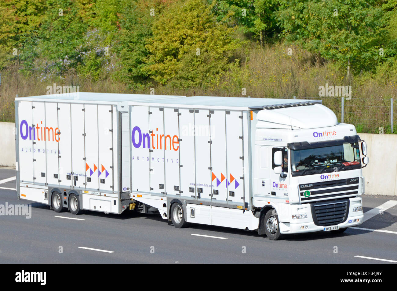 Front side view of Ontime automotive transport business enclosed car delivery hgv lorry truck & trailer operator company logo driving on UK motorway Stock Photo