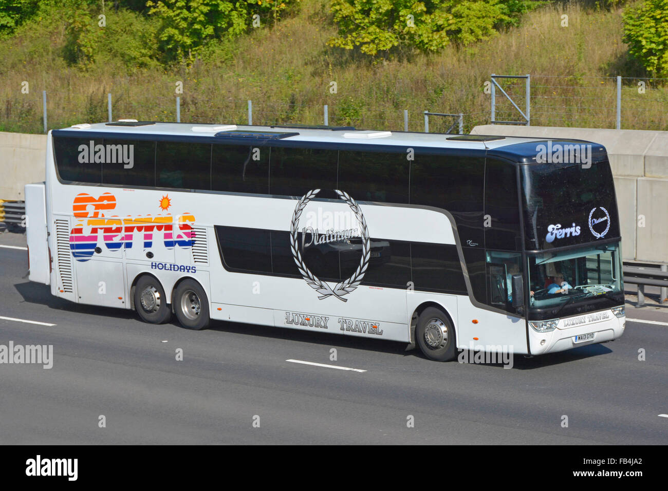 Ferris Holidays Luxury Travel business double decker coach bus transport & driver with dark tinted windows driving along UK motorway Stock Photo