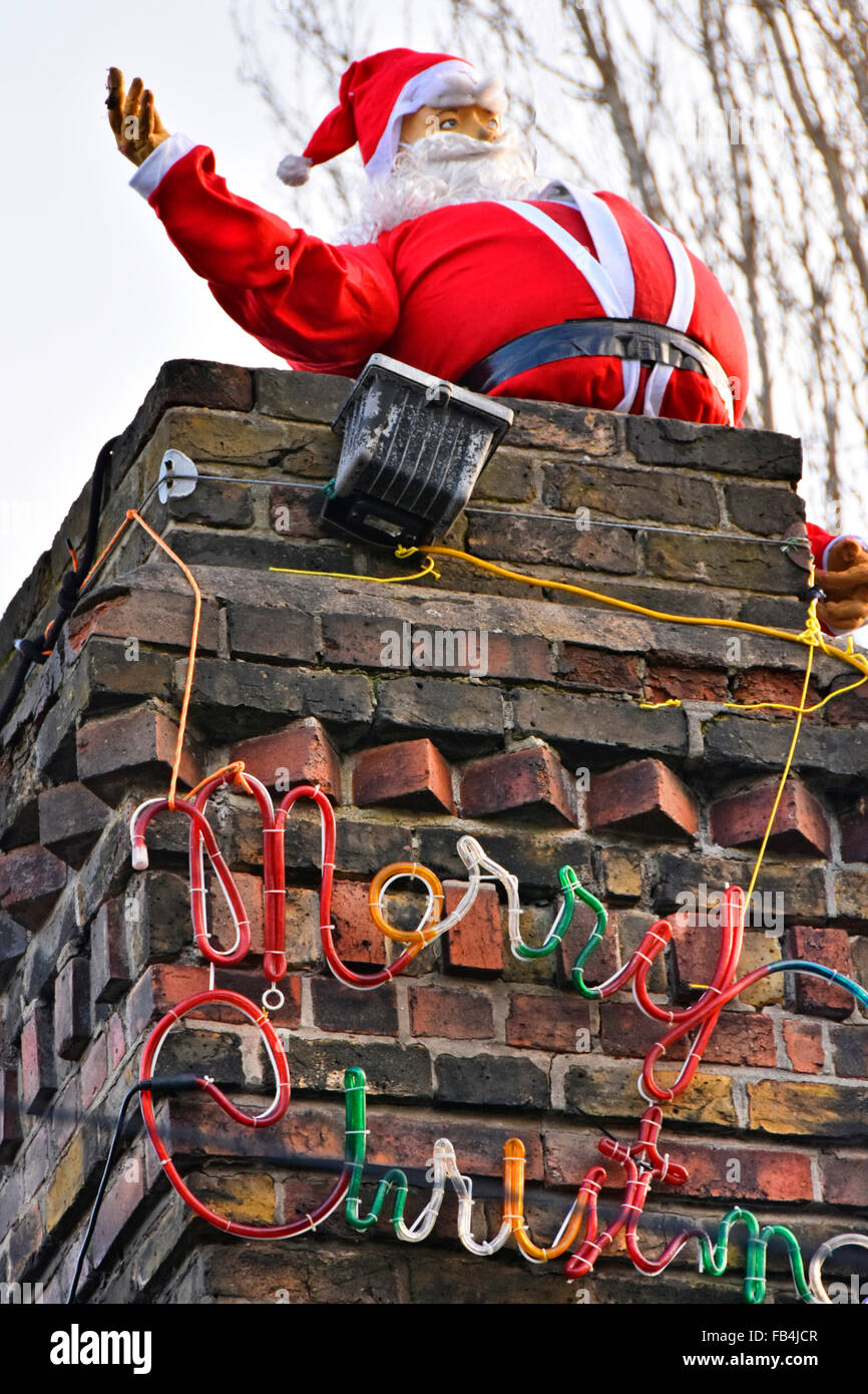 Father Christmas on the top of a real house chimney stack with