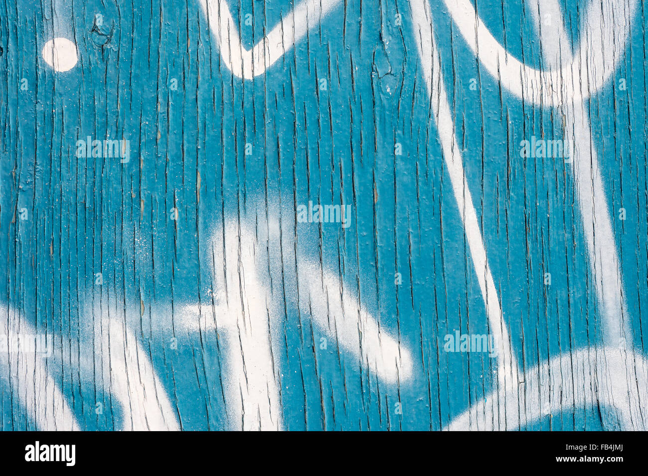Vertical Lines of Peeling blue paint on wooden wall, with white spray paint markings Stock Photo