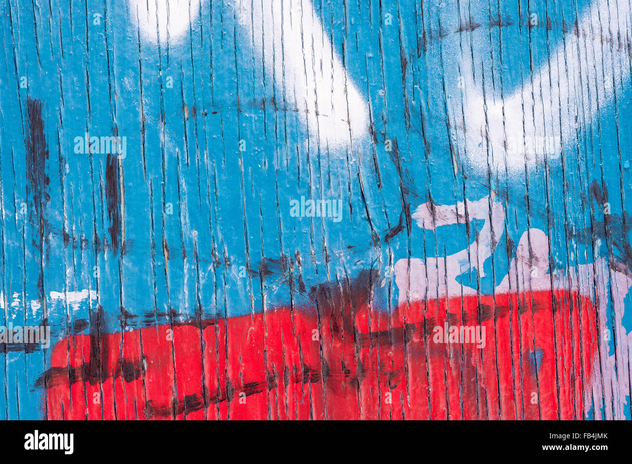 Vertical Lines of Peeling blue paint on wooden wall, with red and white spray paint markings Stock Photo