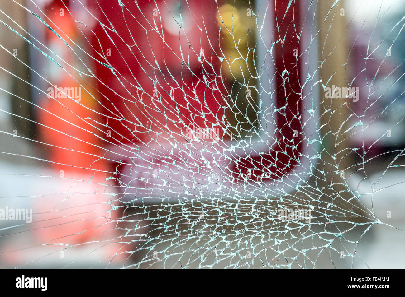 Cracked Shop Window Glass looking like a spider web, with red background Stock Photo