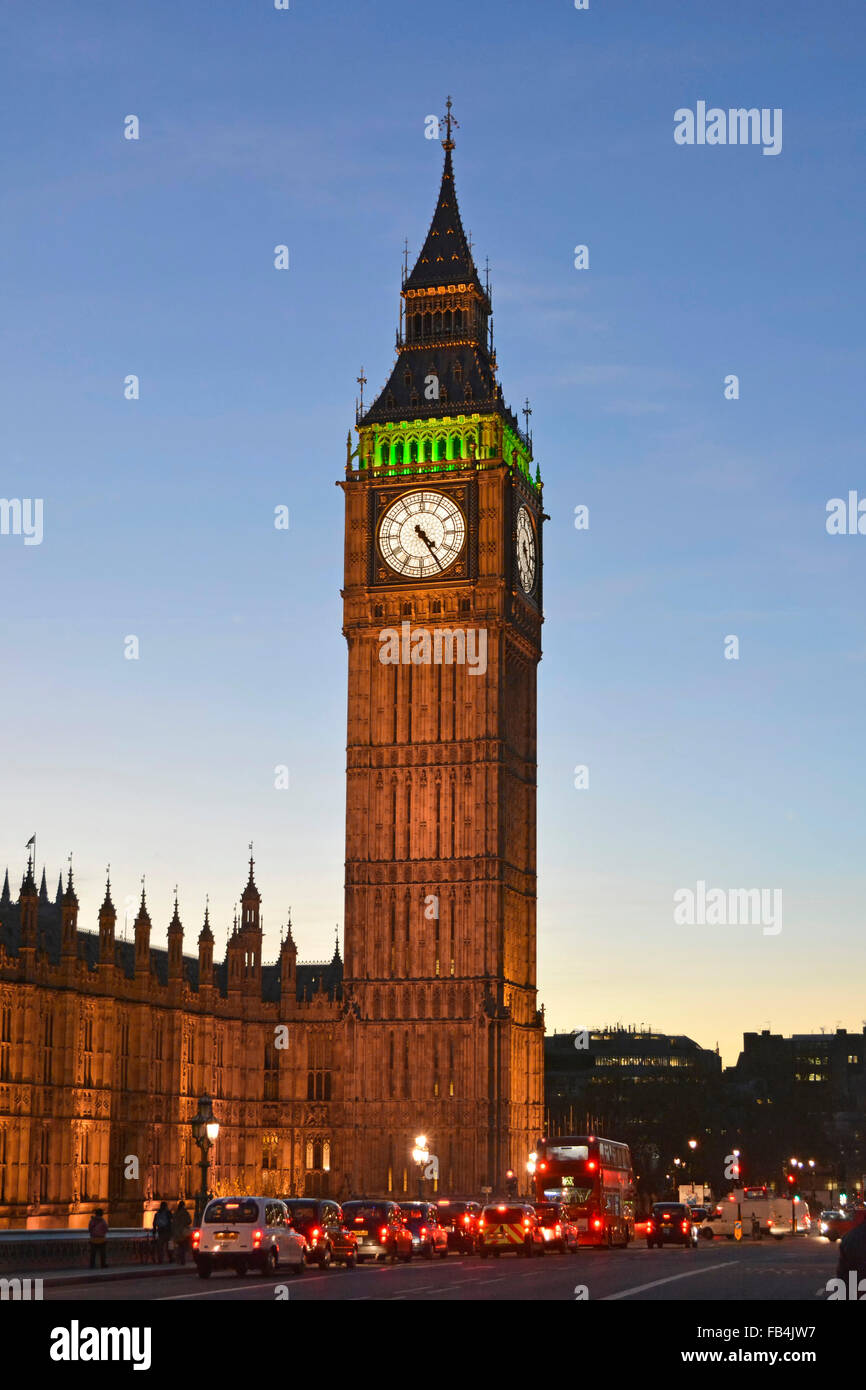 Big Ben clock tower floodlight dusk with vehicles at traffic lights on Westminster Bridge London England UK Stock Photo