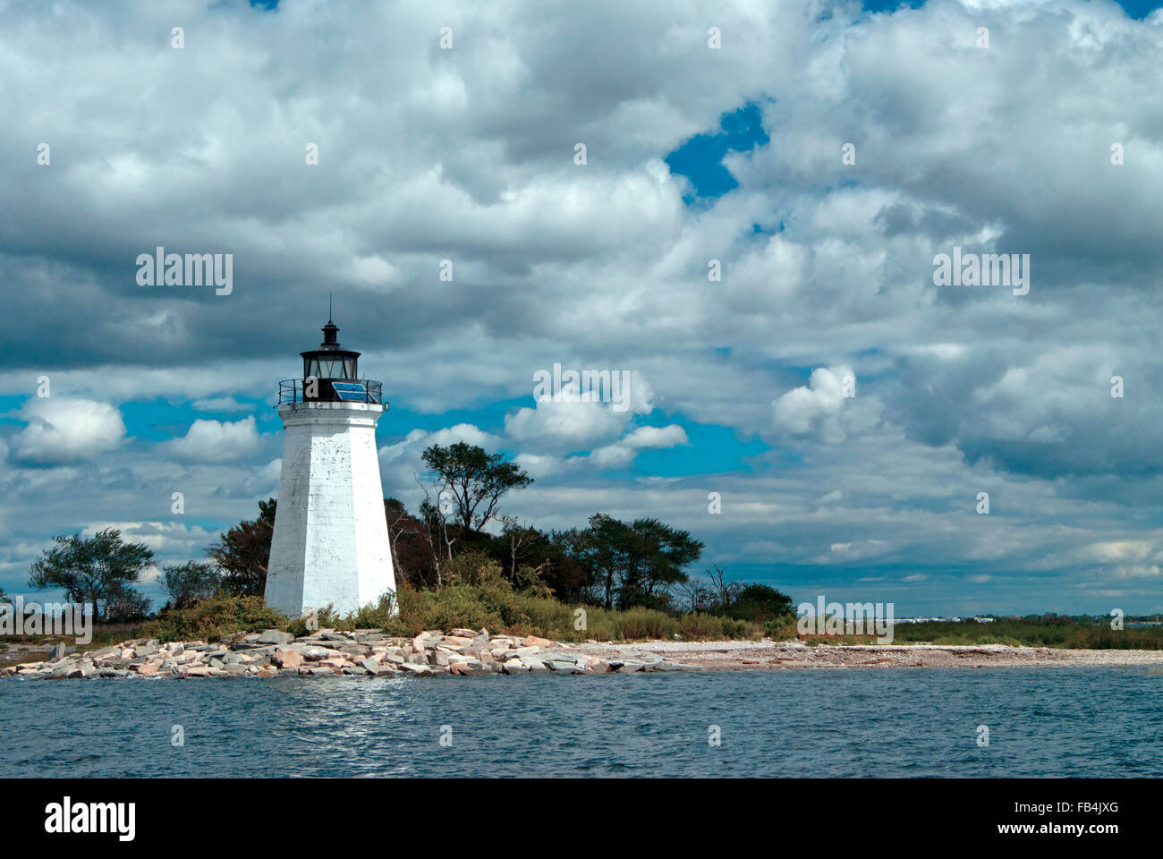 Sun breaks through clouds to shine on historic Black Rock Harbor lighthouse tower on Fayerweather Island, in Bridgeport, Connecticut. Stock Photo