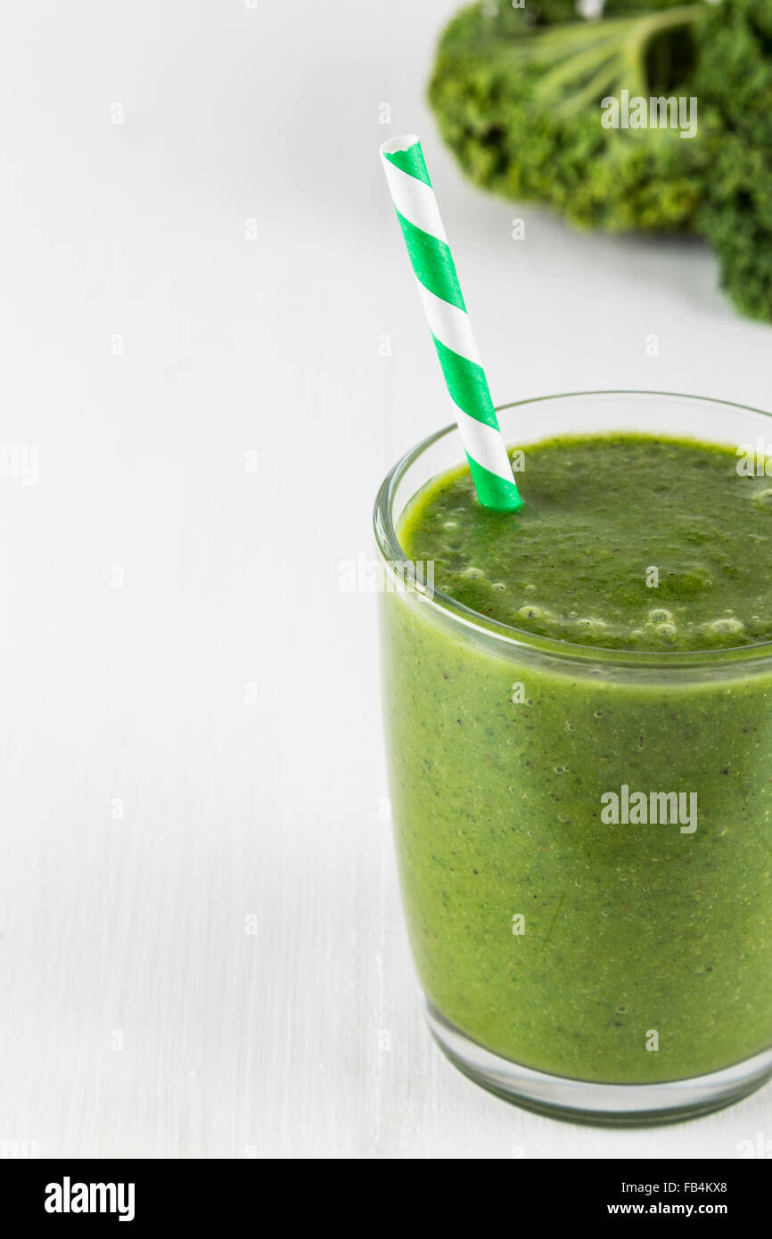 Green kale smoothie with striped straw Stock Photo
