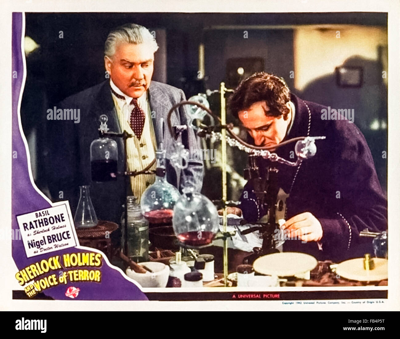 Lobby card for 'Sherlock Holmes and the Voice of Terror' 1942 featuring Sherlock Holmes in his laboratory. Directed by Roy William Neill and starring Basil Rathbone (Holmes); Nigel Bruce (Watson) and Evelyn Ankers (Kitty). See description for more information. Stock Photo