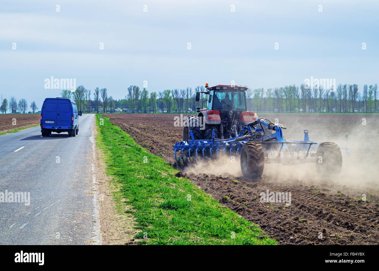 The tractor works at an agricultural field Stock Photo Alamy