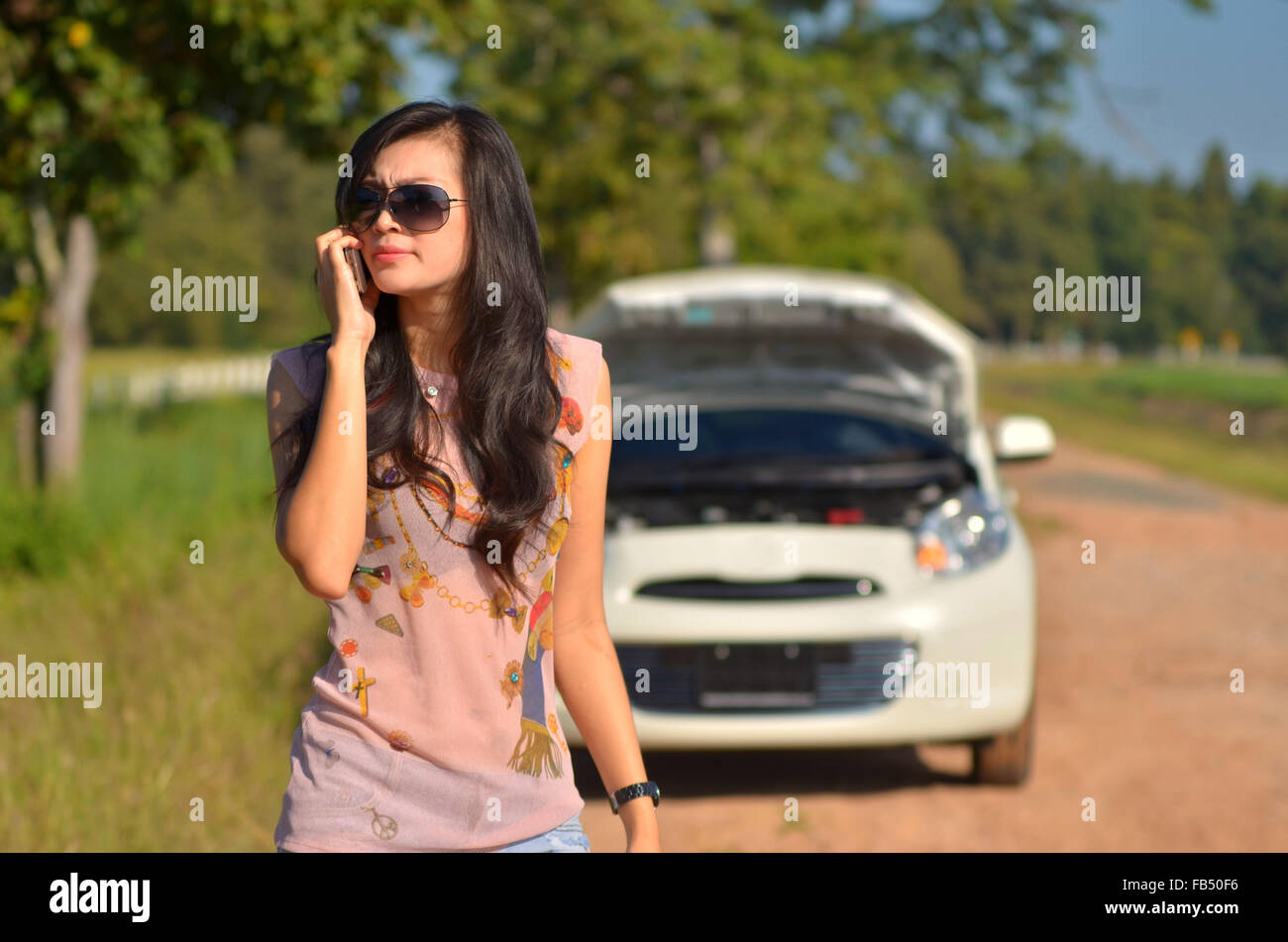 A woman calls for assistance after her car broke down Stock Photo - Alamy